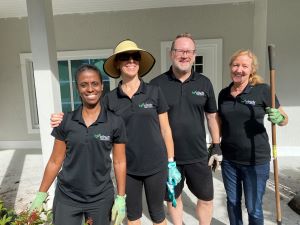 Four Cinch employees, wearing their black Cinch Home Services' polos, volunteering at the Homes For Our Troops event